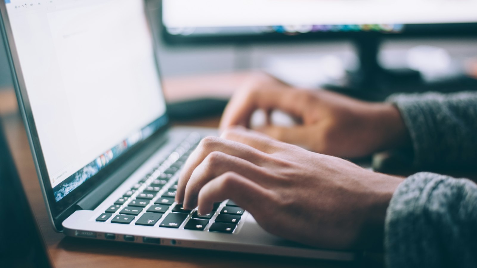 A laptop open on a wooden desk