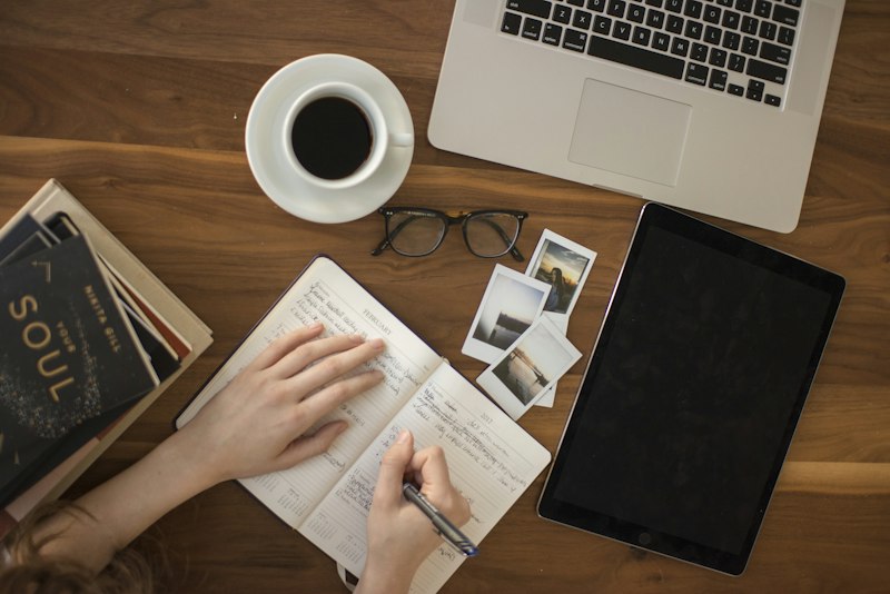 A bright desk from above with stationery and a notebook