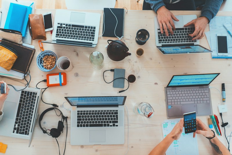 A team working together around laptops at a table